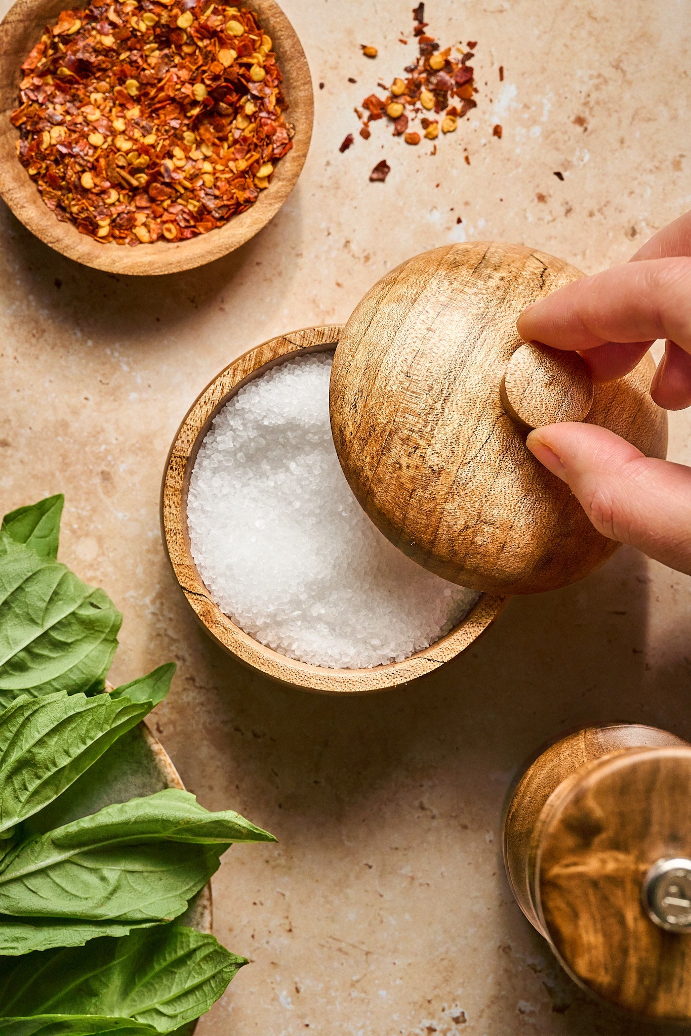 Shop handmade wooden salt cellars - Overhead shot of a hand lifting the lid off a handmade wood salt cellar