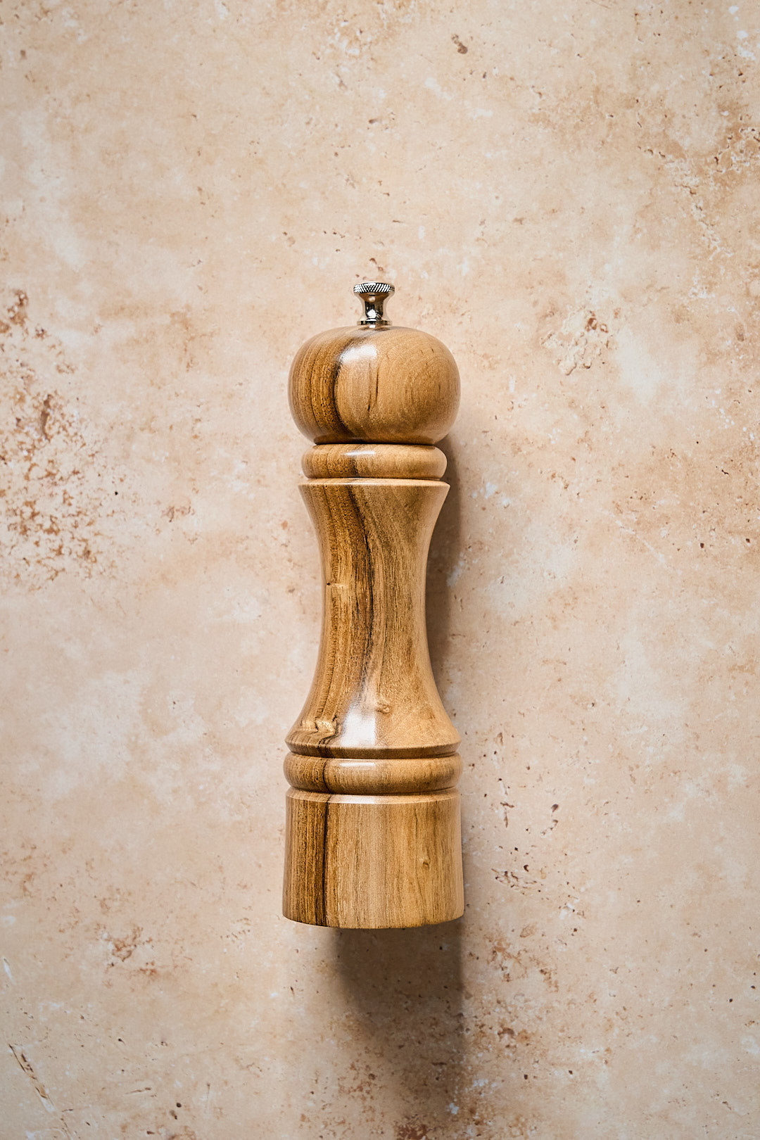 Handmade walnut pepper mill shown on a classic countertop, showcasing its elegant design and professional-grade mechanism.