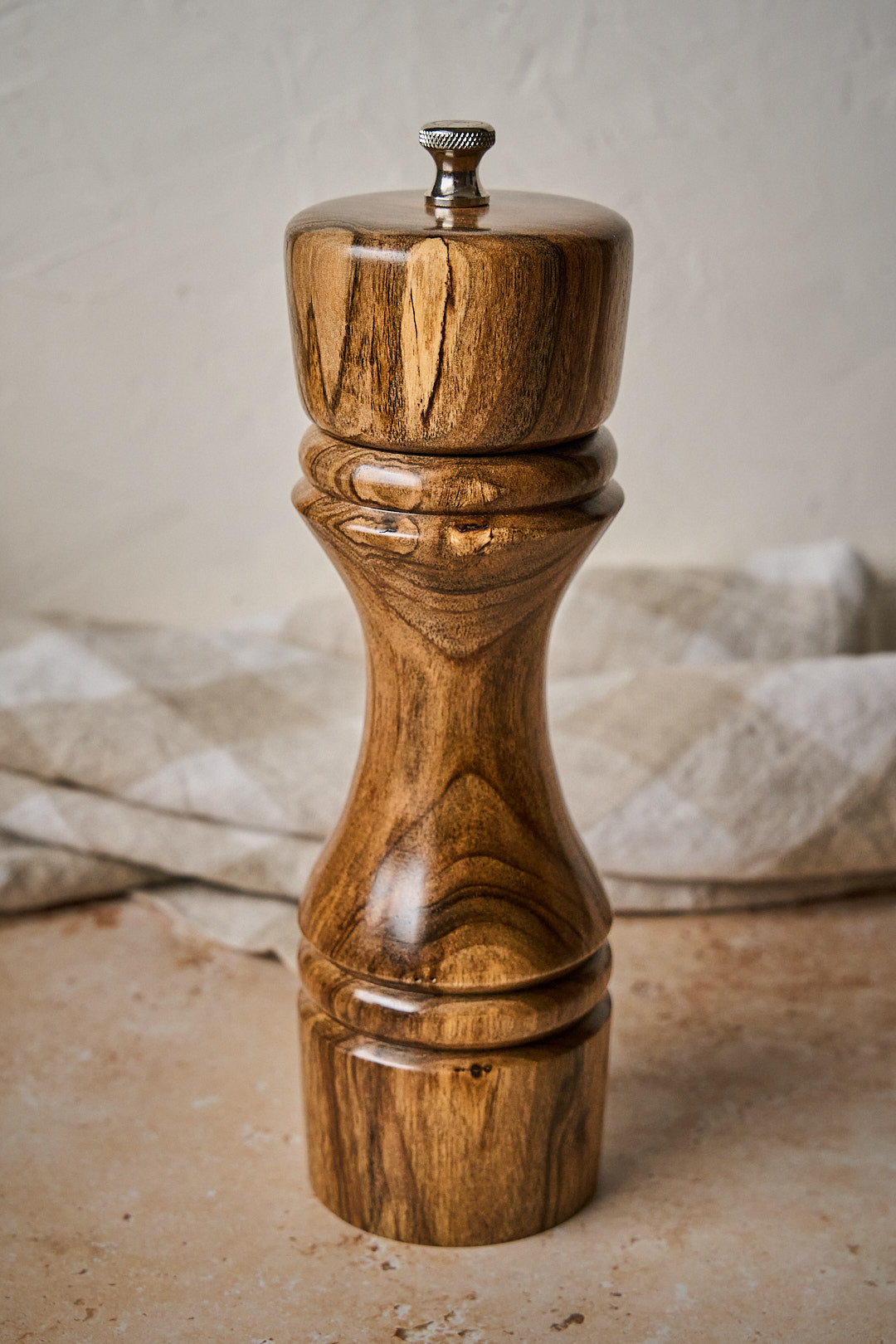 Close up of handmade walnut pepper grinder showing beautiful wood grain