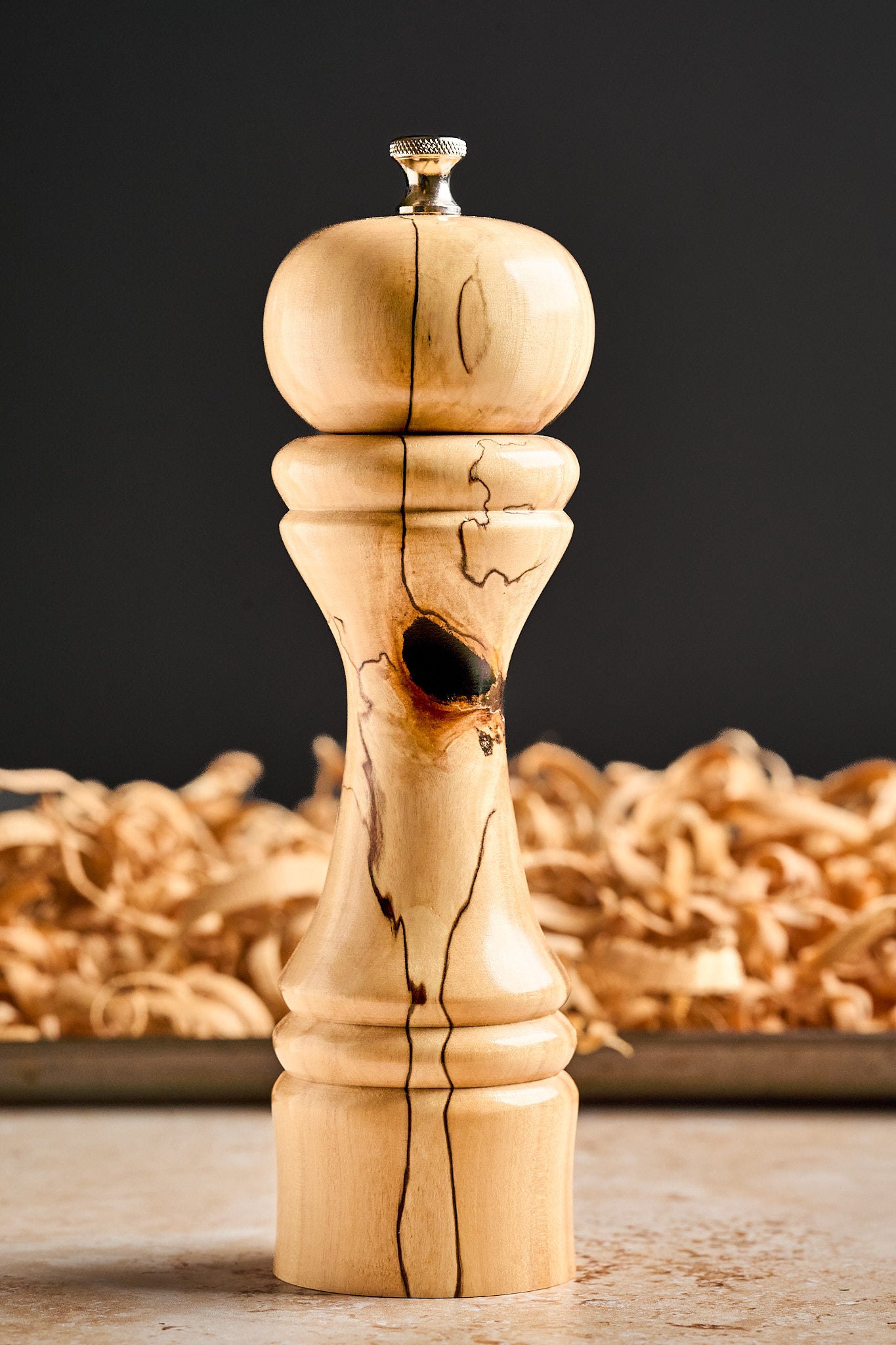 Side view of the unique pepper grinder with a black background