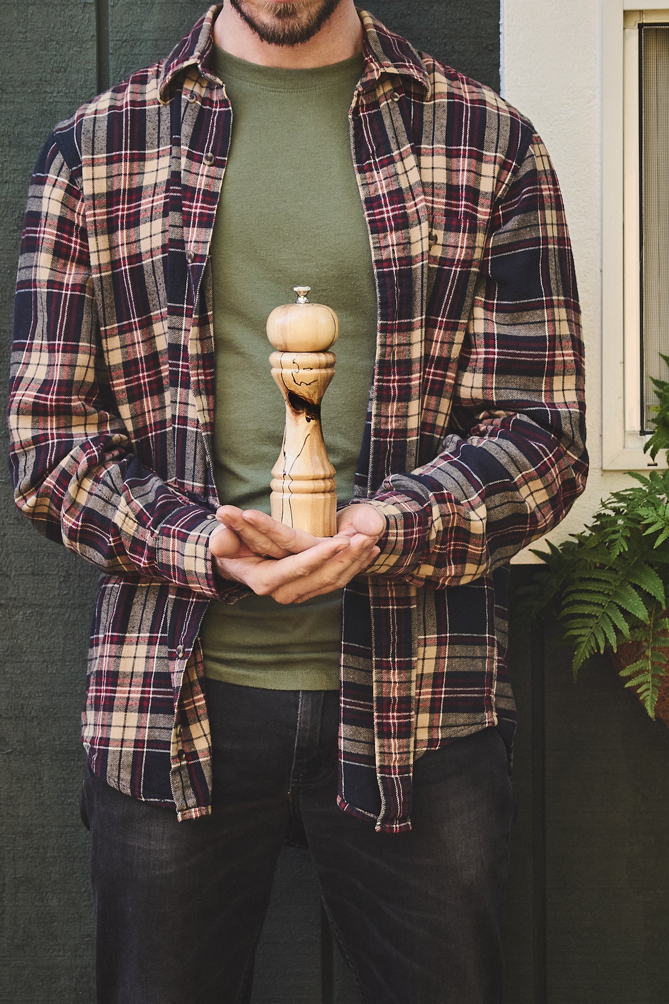 The craftsman holds the unique pepper grinder he made from a fallen apple tree