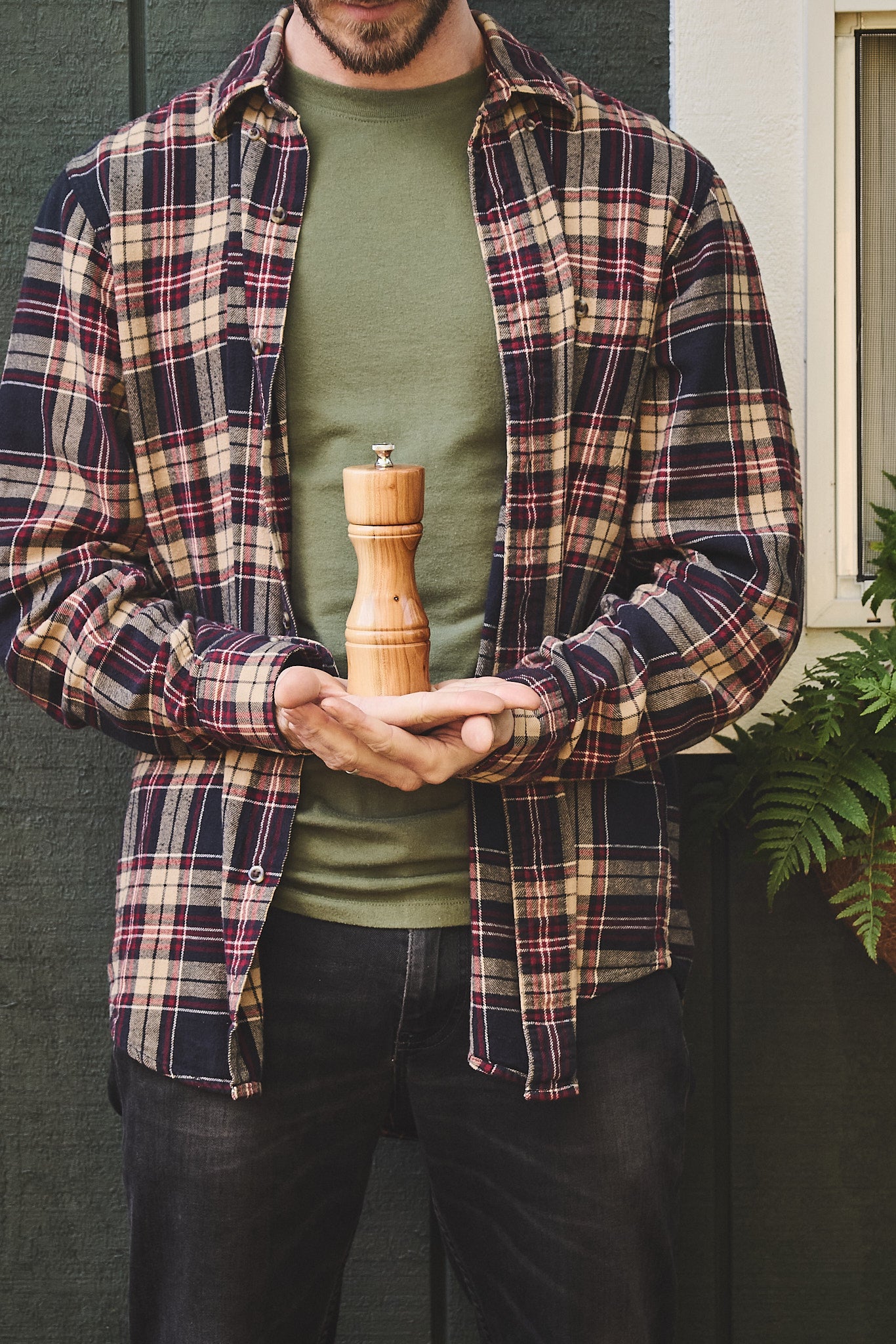 The artist holds the modern pepper mill in his hands outside his Oregon woodshop