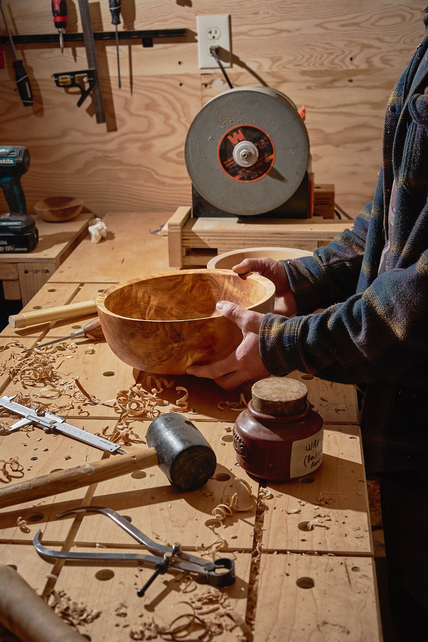 The maker's hands inspecting the bowl
