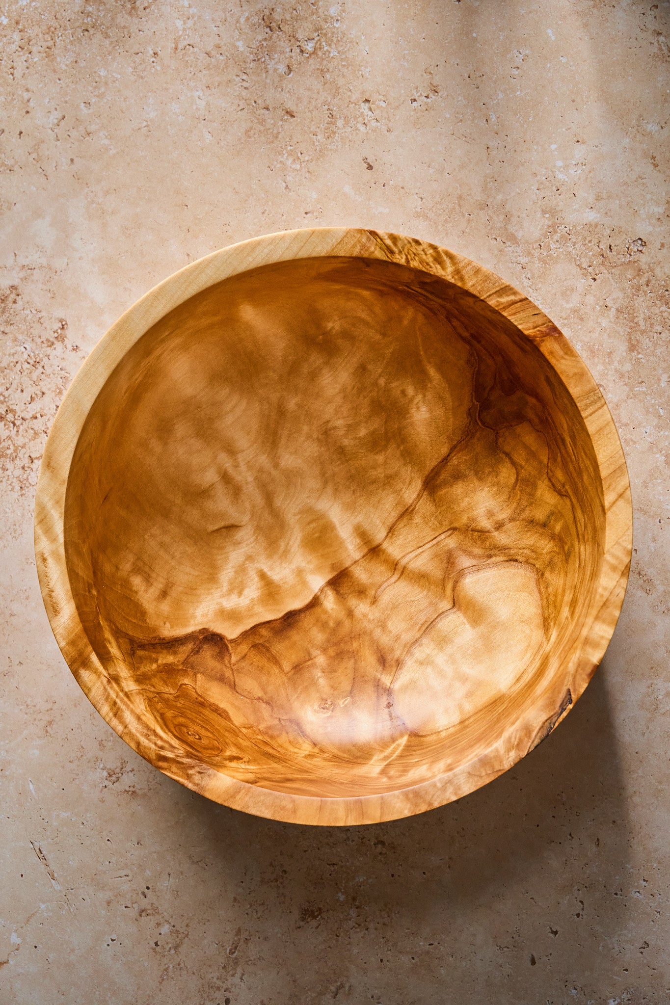 Close-up showing the intricate patterns inside the big wood salad bowl made ofbirch.